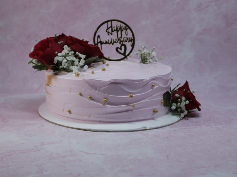 Single-tier anniversary cake with roses and a gold topper at The Bakest, Okhla