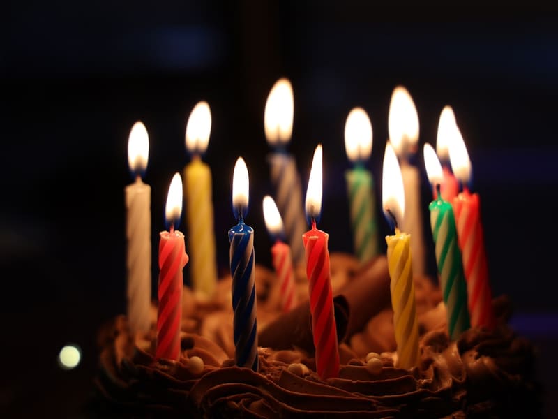 Birthday cake topped with lit candles, custom baked at The Bakest, Okhla